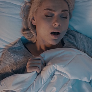 Blonde woman lying in bed snoring